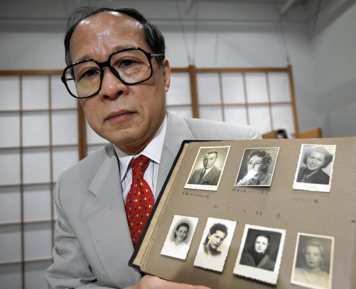 Akira Kitade, in July 2010, holds an album showing seven of those helped by former colleague Tatsuo Osako.