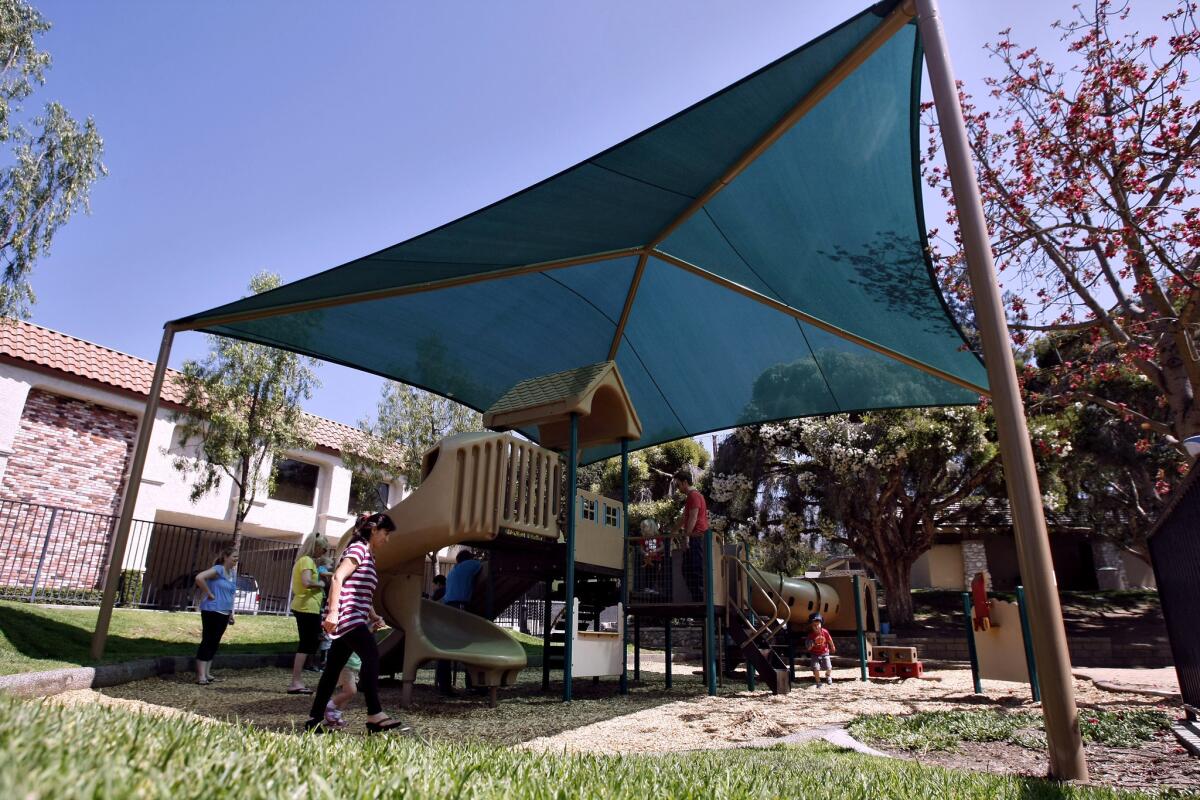 Children play under the shade at the playground in Memorial Park in La Canada Flintridge on Tuesday, June 18, 2013. The city recently installed the large cover to provide protection from the elements of nature.