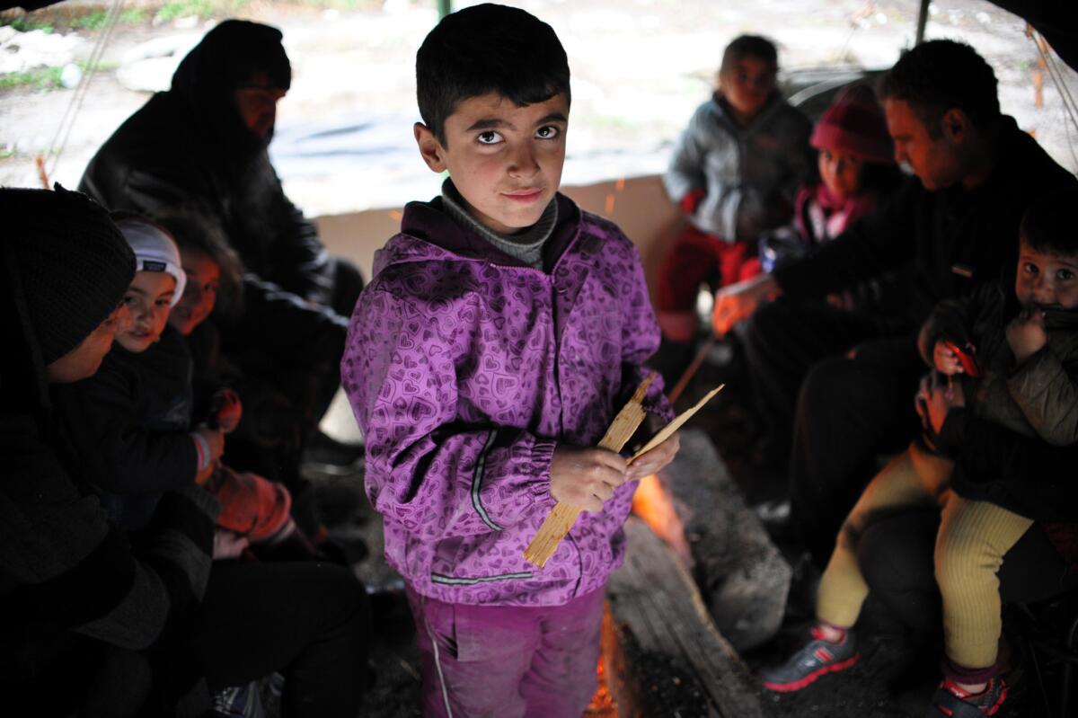 A boy holds wooden sticks in a tent of a refugee camp set in the Bulgarian town of Harmanli, south-east of Sofia. Bulgaria's asylum centers are severely overcrowded after the arrival of almost 10,000 refugees this year, half of them Syrian.