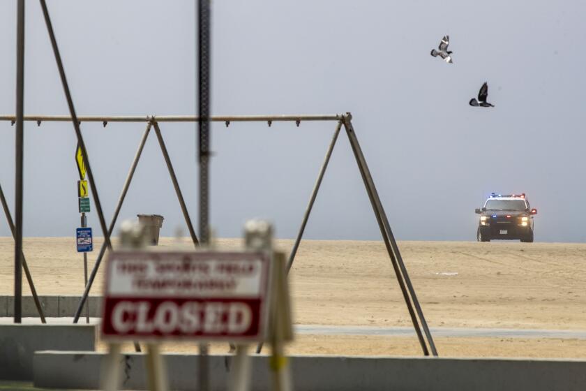 SANTA MONICA, CA - APRIL 25: Santa Monica police keep watch over the empty beach and closed bike path as law enforcement presence was heavy along the coast to keep people off of closed Los Angeles County beaches on Saturday, April 25, 2020 in Santa Monica, CA. (Brian van der Brug / Los Angeles Times)
