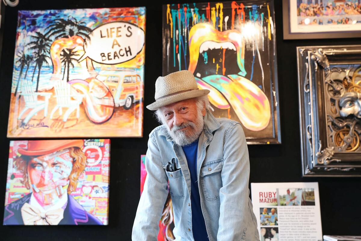 Ruby Mazur stands with a variety of his work on display at the Bill Mack Gallery in Laguna Beach.