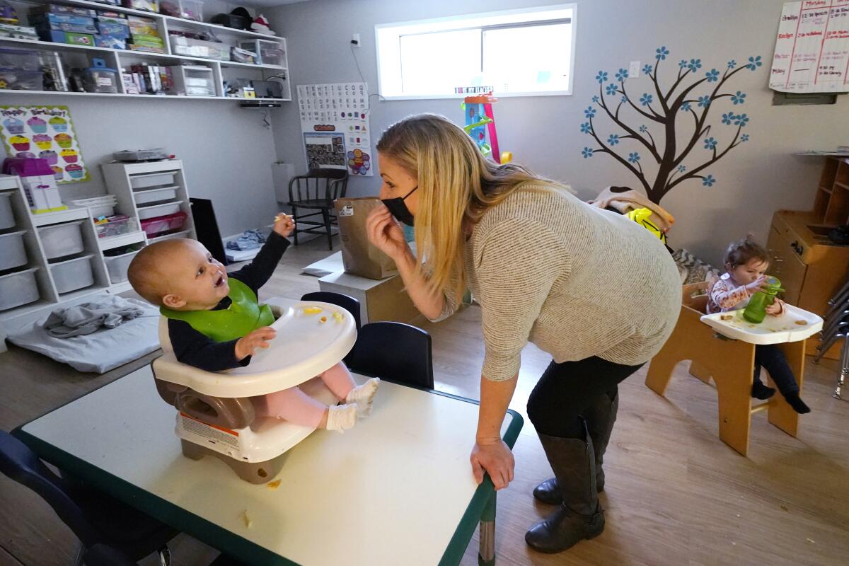 Amy McCoy signs to a 7-month-old baby at her Forever Young Daycare facility in Mountlake Terrace, Wash., on Oct. 25, 2021.