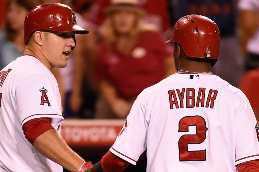 Angels shortstop Erick Aybar, right, is congratulated by teammate Mike Trout after scoring in the eighth inning of the team's 3-2 win over the Baltimore Orioles on July 23.