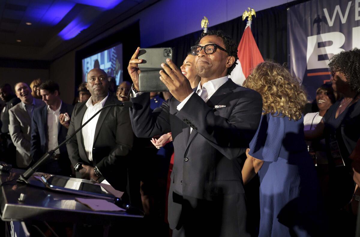 Wesley Bell, on stage, takes a video of his supporters 