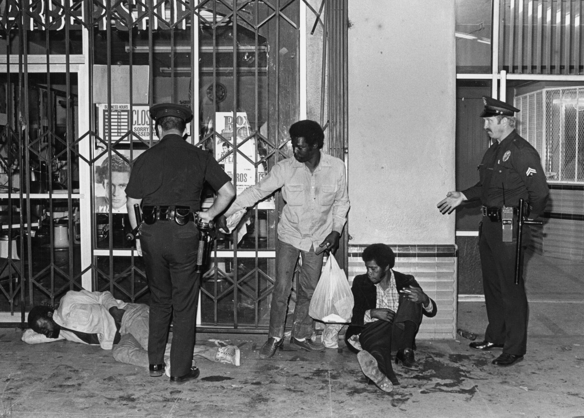 LAPD officers talk to people living on the streets of Skid Row in 1986.