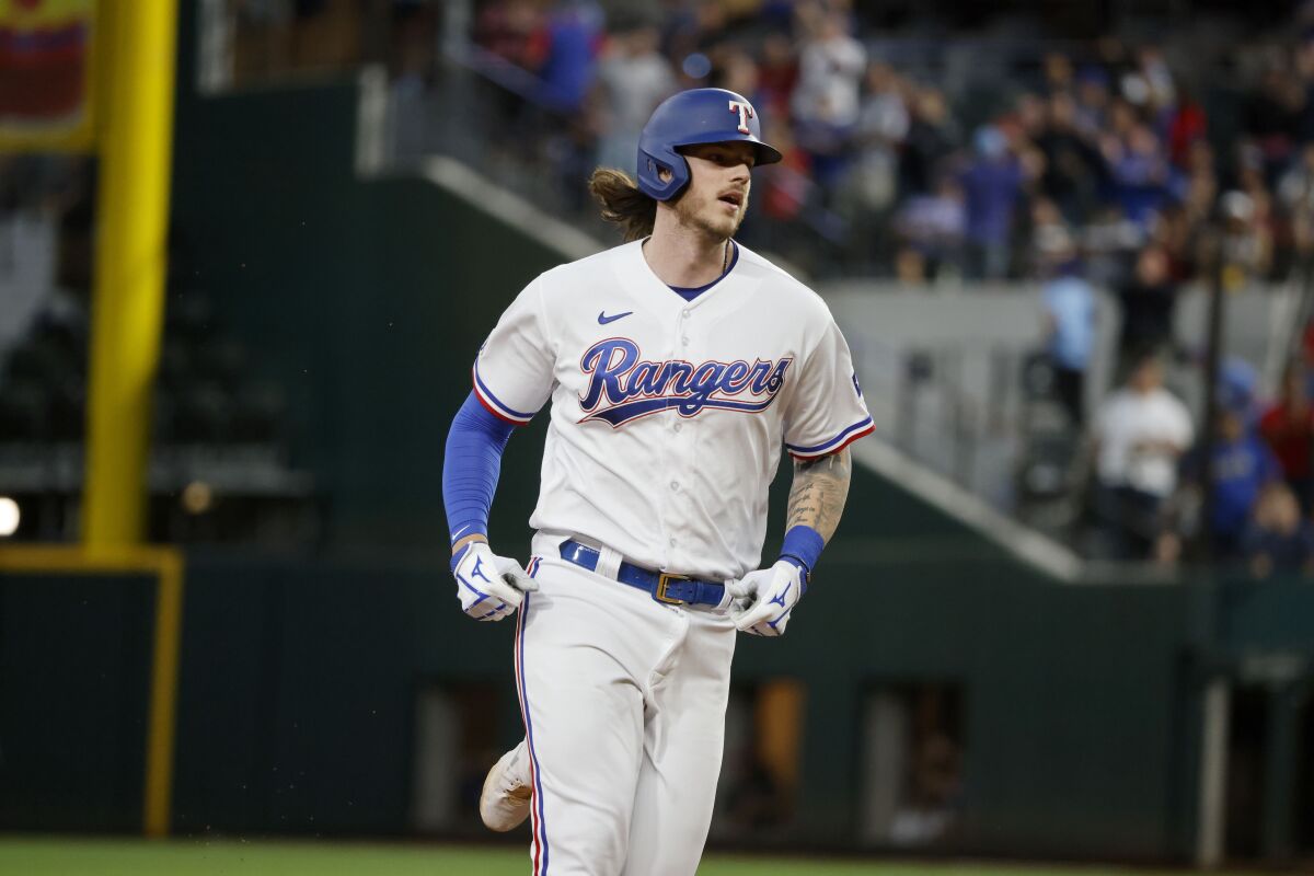 Texas Rangers' Jonah Heim runs the bases after hitting a grand slam against the Los Angeles Angels during the second inning of a baseball game Thursday, April 14, 2022, in Arlington, Texas. (AP Photo/Michael Ainsworth)
