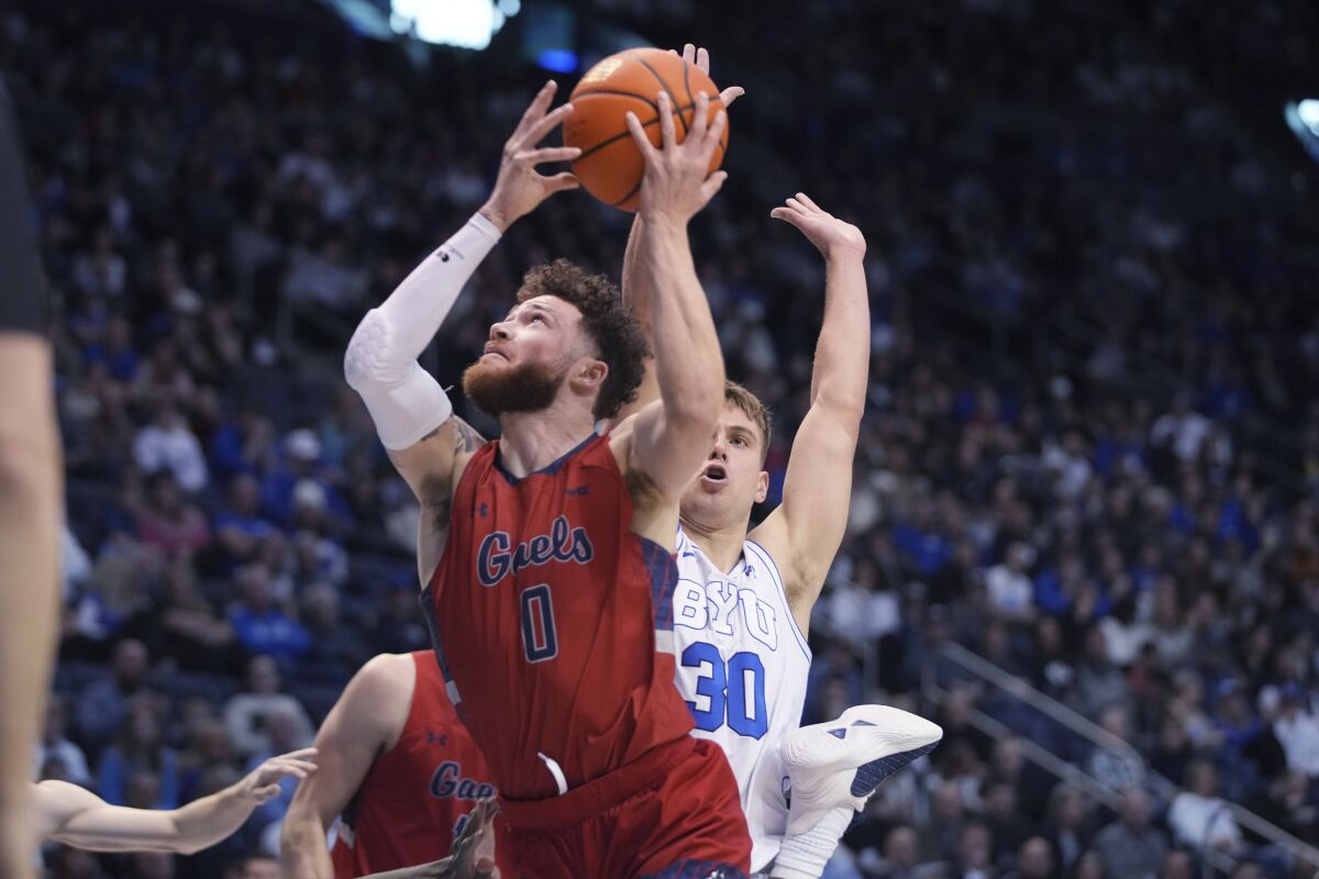 Saint Mary's guard Logan Johnson (0) lays the ball in past BYU guard Dallin Hall (30) during the first half of an NCAA college basketball game Saturday, Jan. 28, 2023, in Provo, Utah. (AP Photo/George Frey)