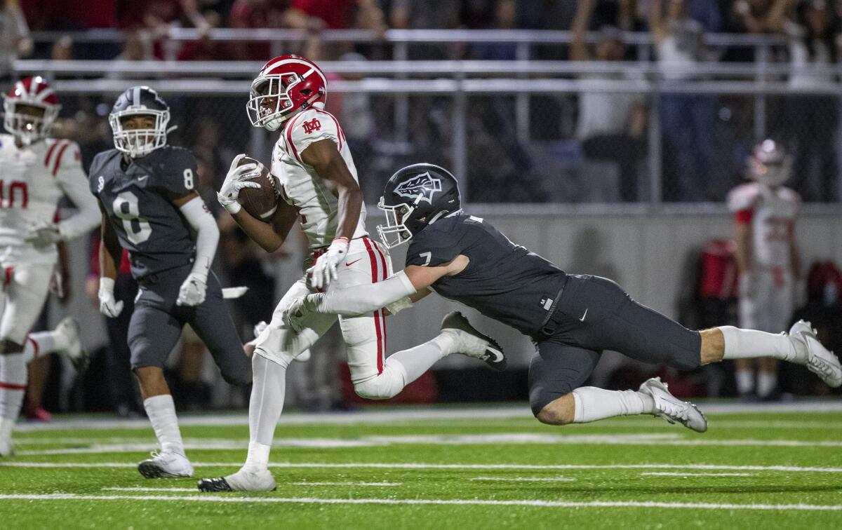 Mater Dei receiver Kody Epps is tacked by St. John Bosco safety Jake Newman during their Trinity League showdown on Oct. 25, 2019.