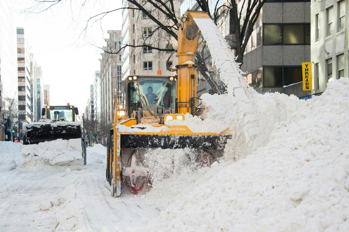 Trucks clear snow from a street in downtown Washington on Jan. 25.