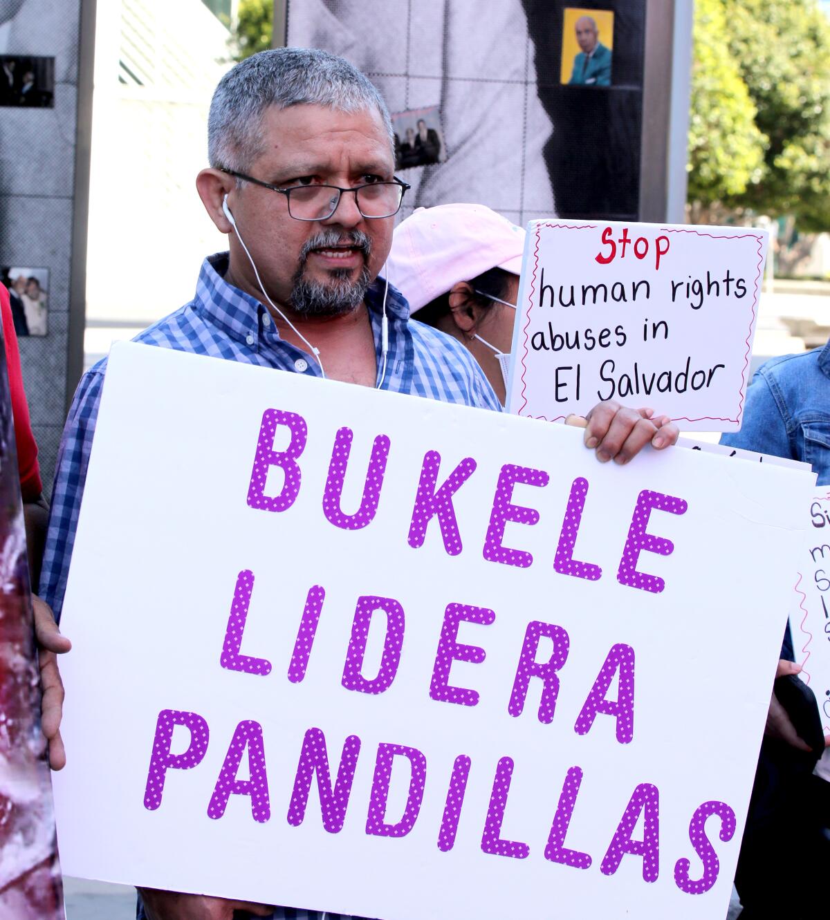 A protester holds a sign reading "Bukele Lider Pandillas."