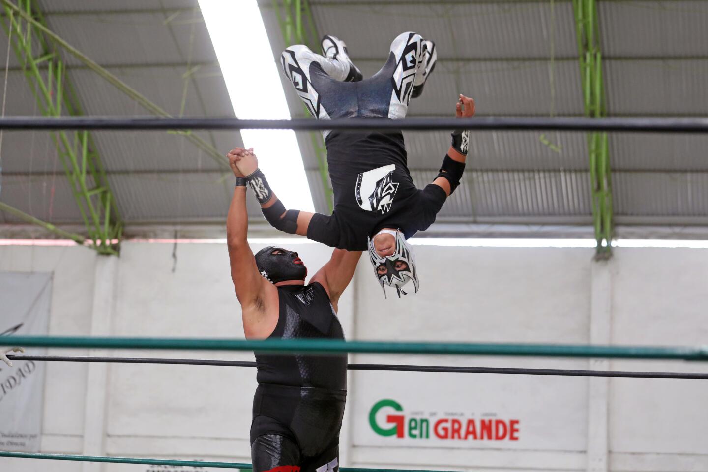 Wrestler Mr. Jack flips Krauzar in the air at a lucha libre event that was broadcast online.
