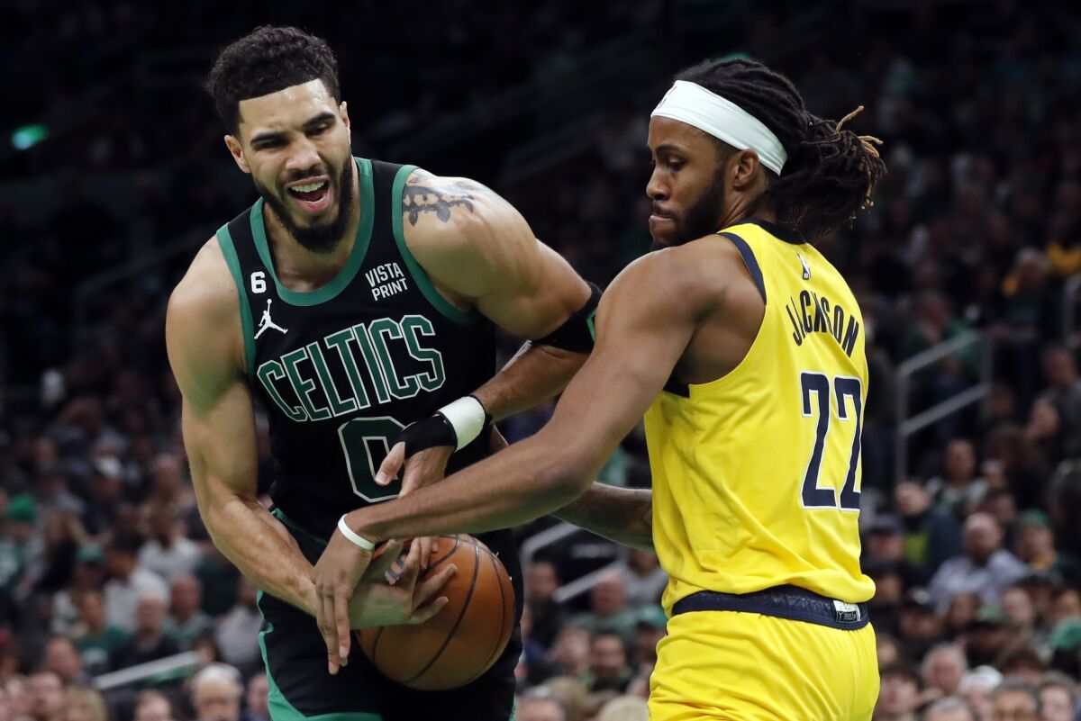 Boston Celtics' Jayson Tatum (0) is defended by Indiana Pacers' Isaiah Jackson (22) during the first half of an NBA basketball game Friday, March 24, 2023, in Boston. (AP Photo/Michael Dwyer)