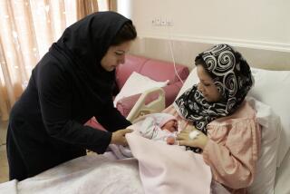Iranian nurse Zahra Akbarzadeh, left, gives one-day-old baby girl Setayesh to her mother, Tayyebeh Sadat Bidaki, to feed her at the Mehr hospital, in Tehran, Sunday, July 29, 2012. In a major reversal of once far-reaching family planning policies, Iran is now slashing its birth-control programs in an attempt to avoid an aging demographic similar to many Western countries that are struggling to keep up with state medical and social security costs. (AP Photo/Vahid Salemi)