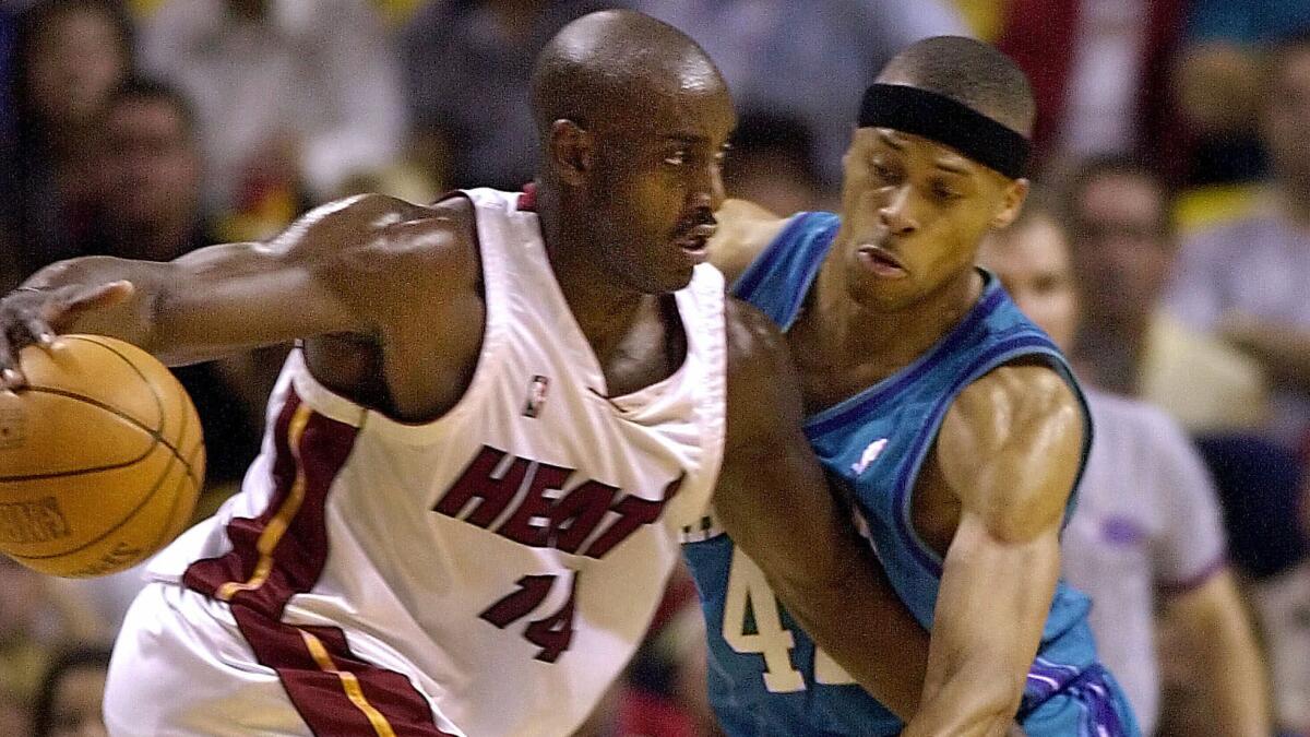 Miami Heat forward Anthony Mason, left, tries to drive past Charlotte Hornets center P.J. Brown during a game in April 2001.