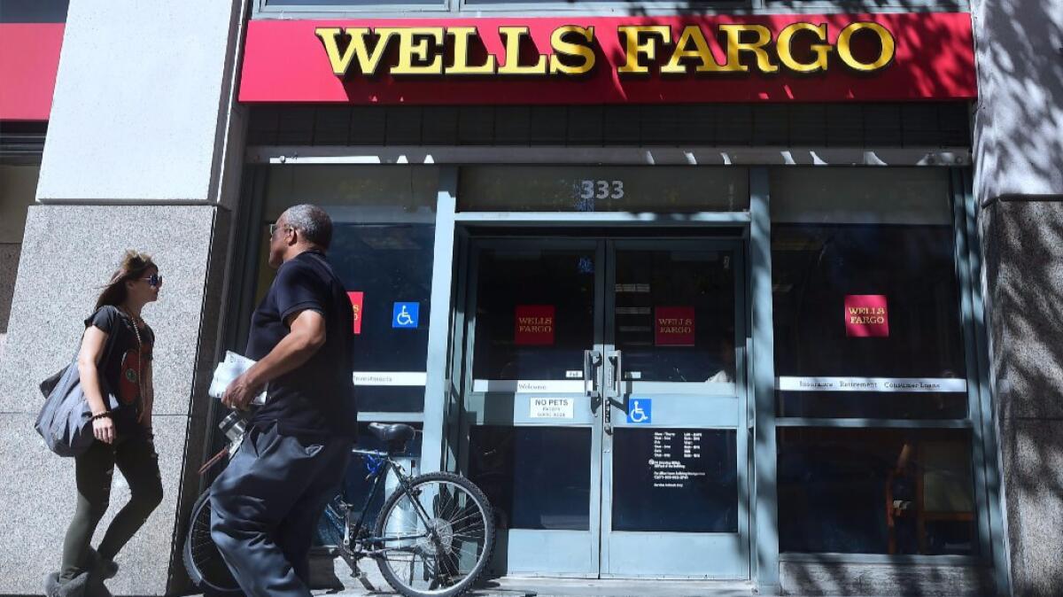 Pedestrians walk past a branch of Wells Fargo bank in downtown Los Angeles on Oct. 3.