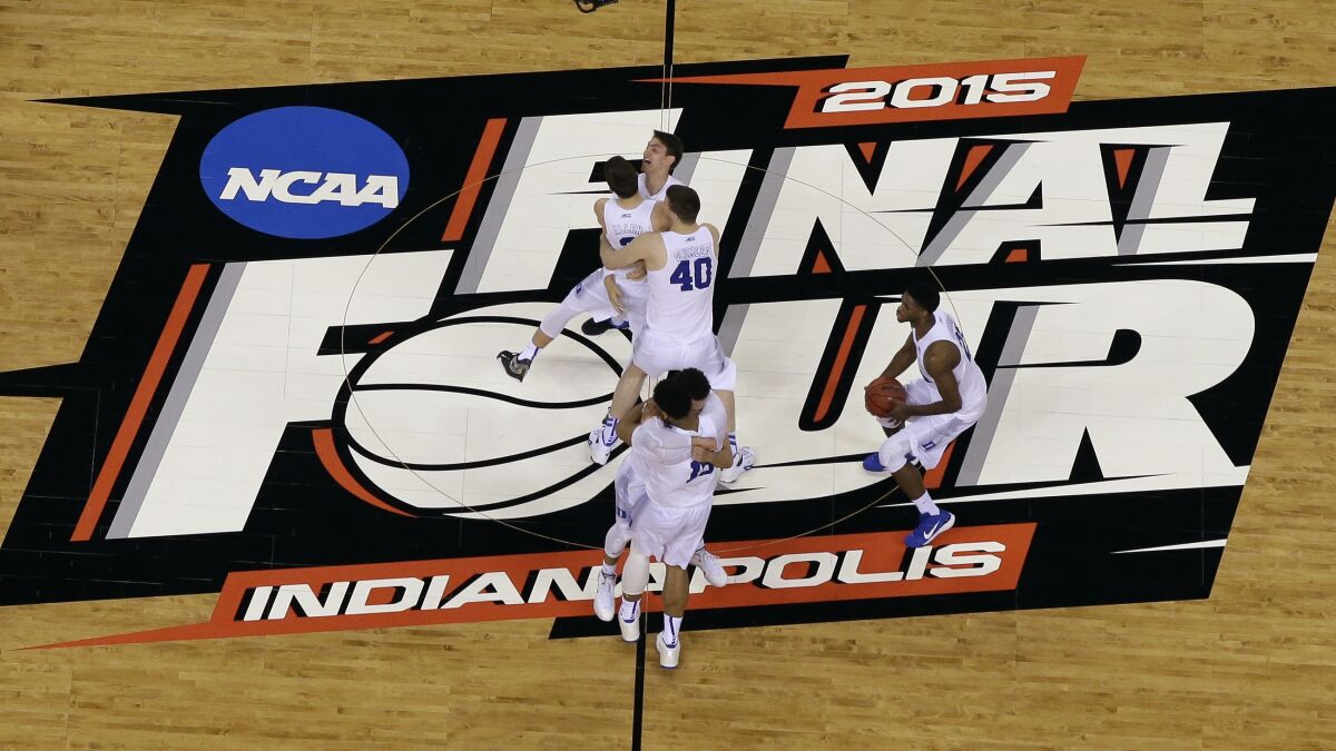 Duke players celebrate on the basketball court after winning the 2015 NCAA championship game.