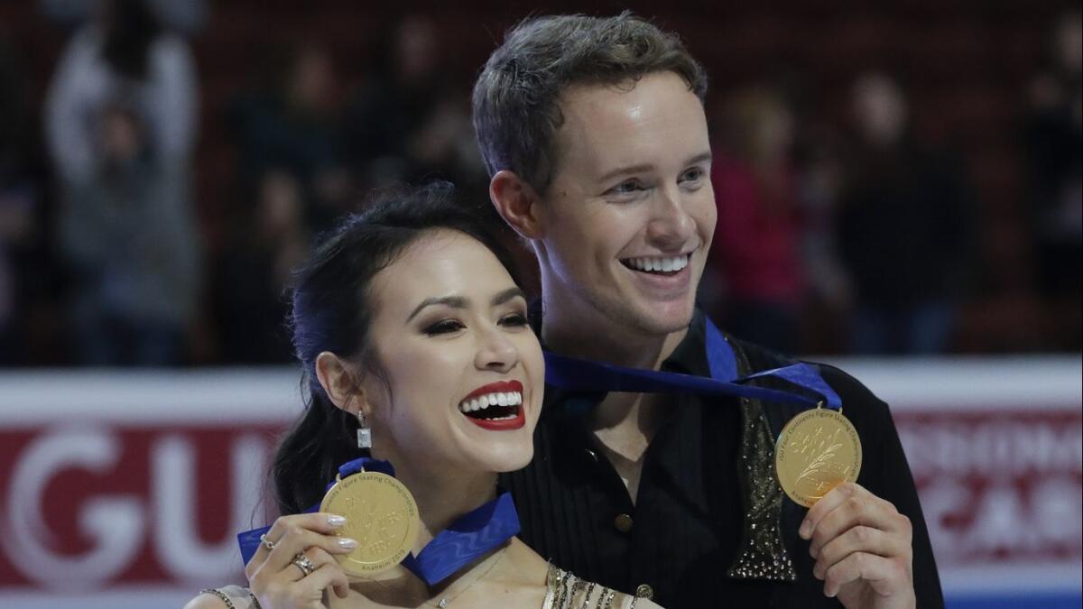 Madison Chock and Evan Bates show off their gold medals after winning the ice dancing competition at the Four Continents Figure Skating Championships at the Honda Center on Sunday.