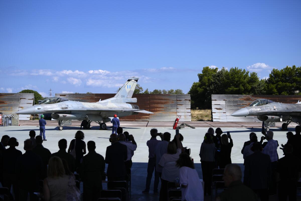 Guests take photographs of the two Greek Fighter Jets F-16 Viper at Tanagra air force base about 74 kilometres (46 miles) north of Athens, Greece, Monday, Sept. 12, 2022. Greece's air force on Monday took delivery of a first pair of upgraded F-16 military jets, under a $1.5 billion program to fully modernize its fighter fleet amid increasing tension with neighboring Turkey. (AP Photo/Thanassis Stavrakis)