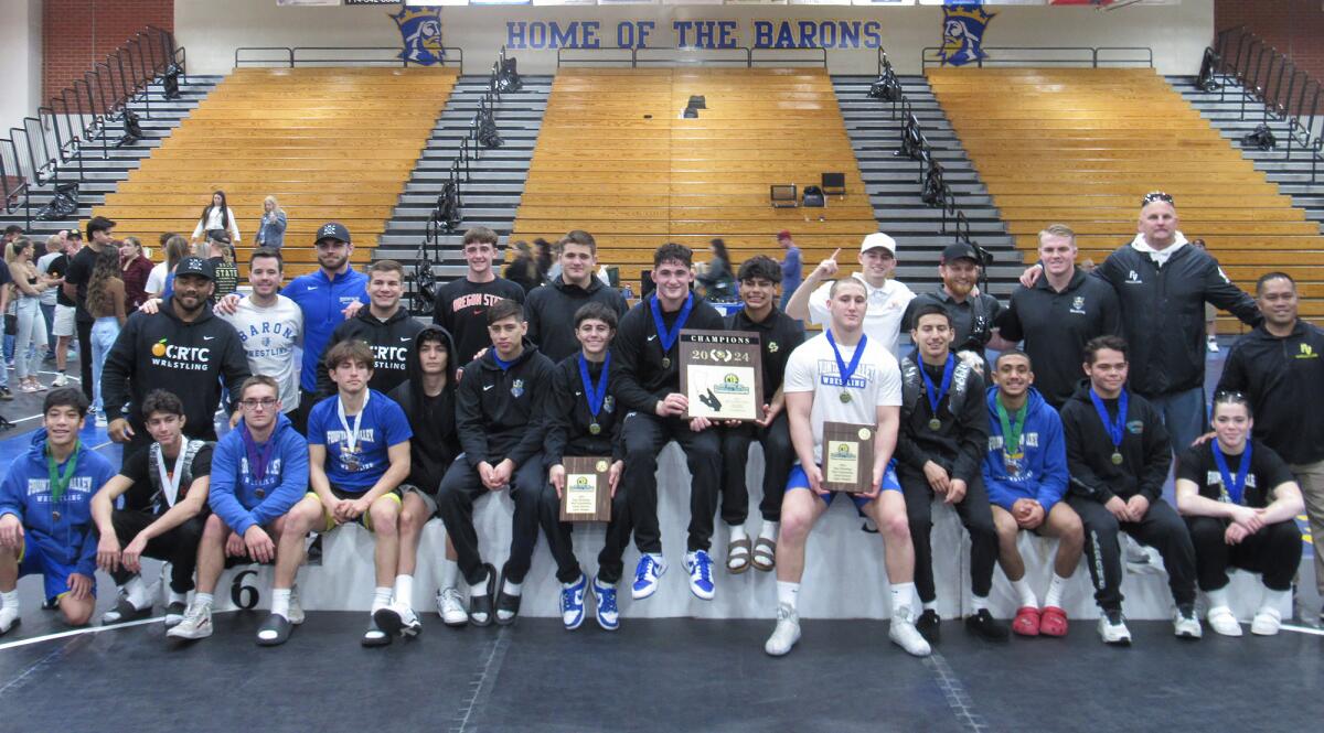 The Fountain Valley wrestling team poses with the championship plaque after winning the CIF Inland Division wrestling finals.