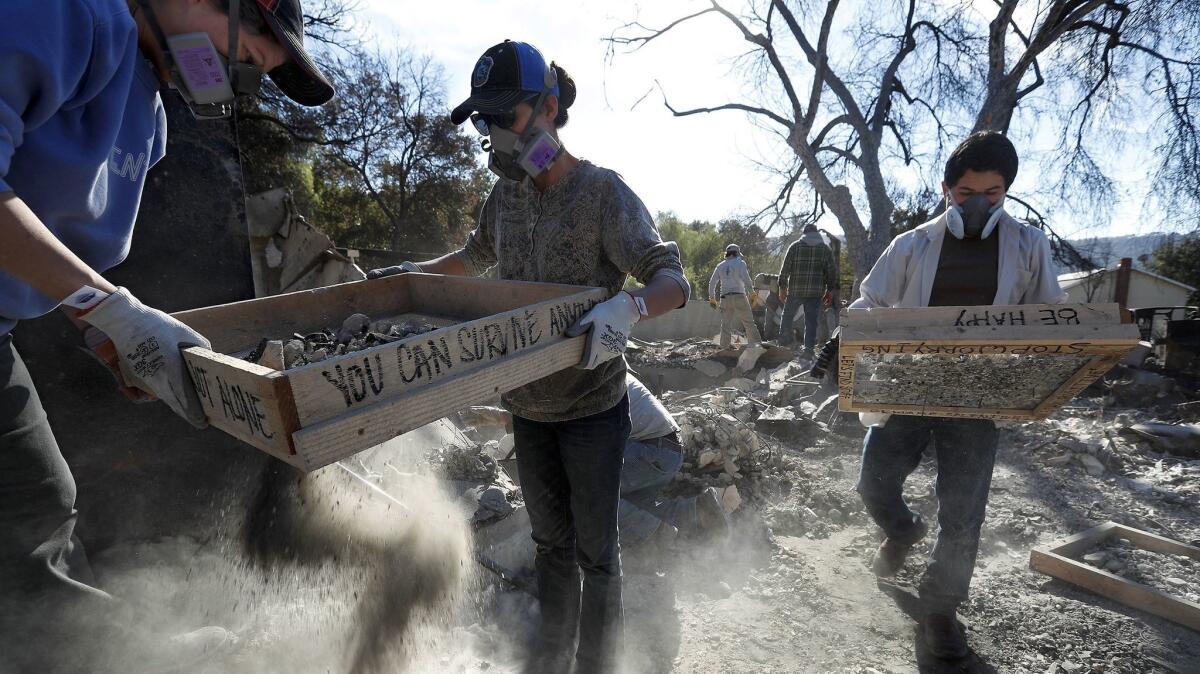 Amanda Rogers, left, and her daughter Naomi help sift through the rubble with other volunteers of the burned home of upper Ojai resident Leona Mote.