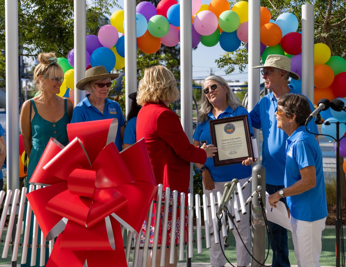 Local officials and library supporters at a musical installation outside the Donald Dungan Library.