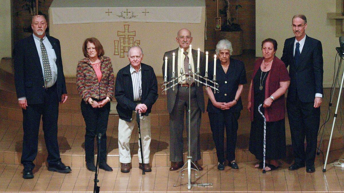 Community members stand with a menorah, with candles lit, in commemoration of the Holocaust for the Days of Remembrance at St. Jude's Angelican Church in Burbank in May 2016.