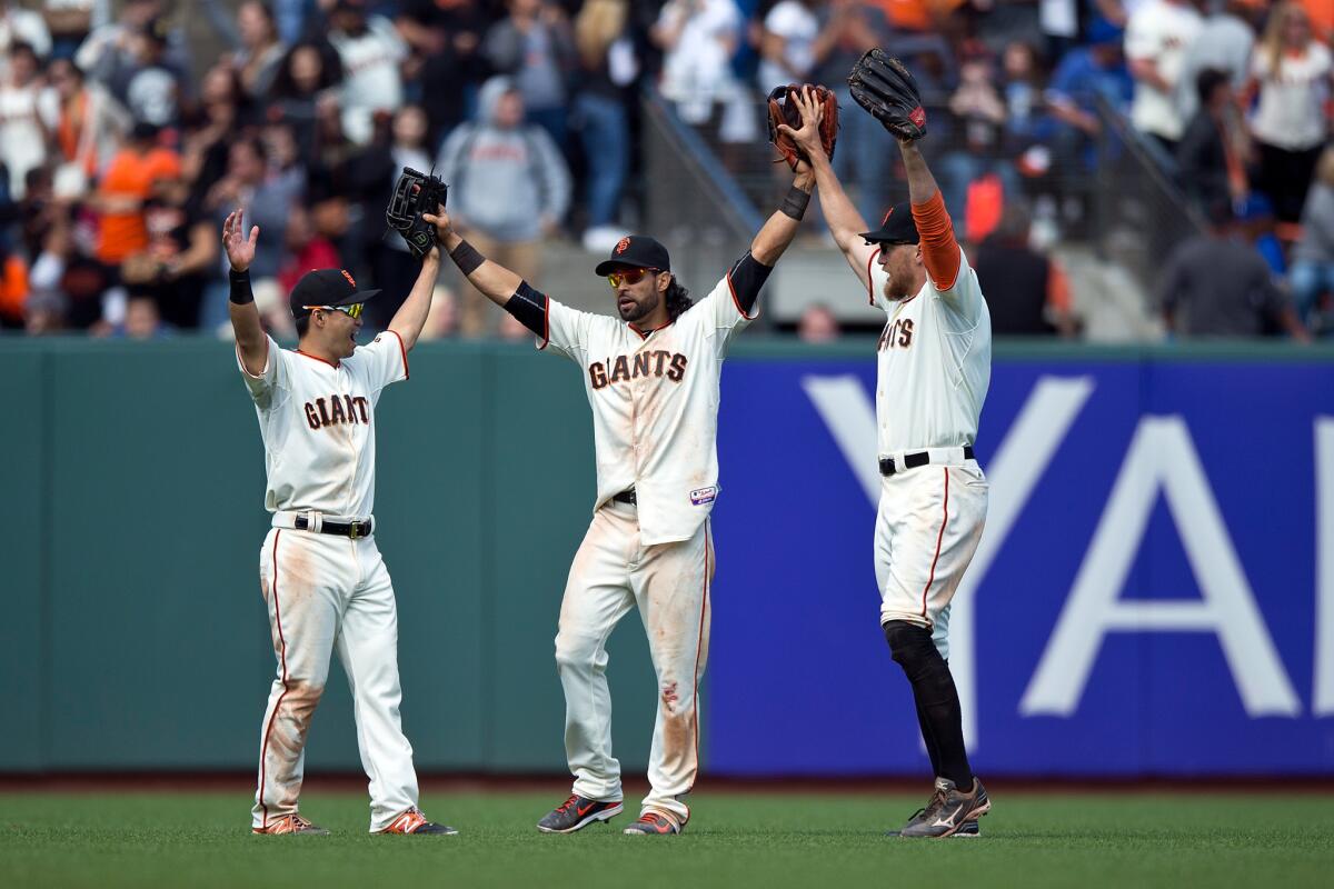 The Giants' Nori Aoki, left, Angel Pagan and Hunter Pence celebrate after beating the Dodgers, 4-0, at AT&T Park on May 21, 2015.
