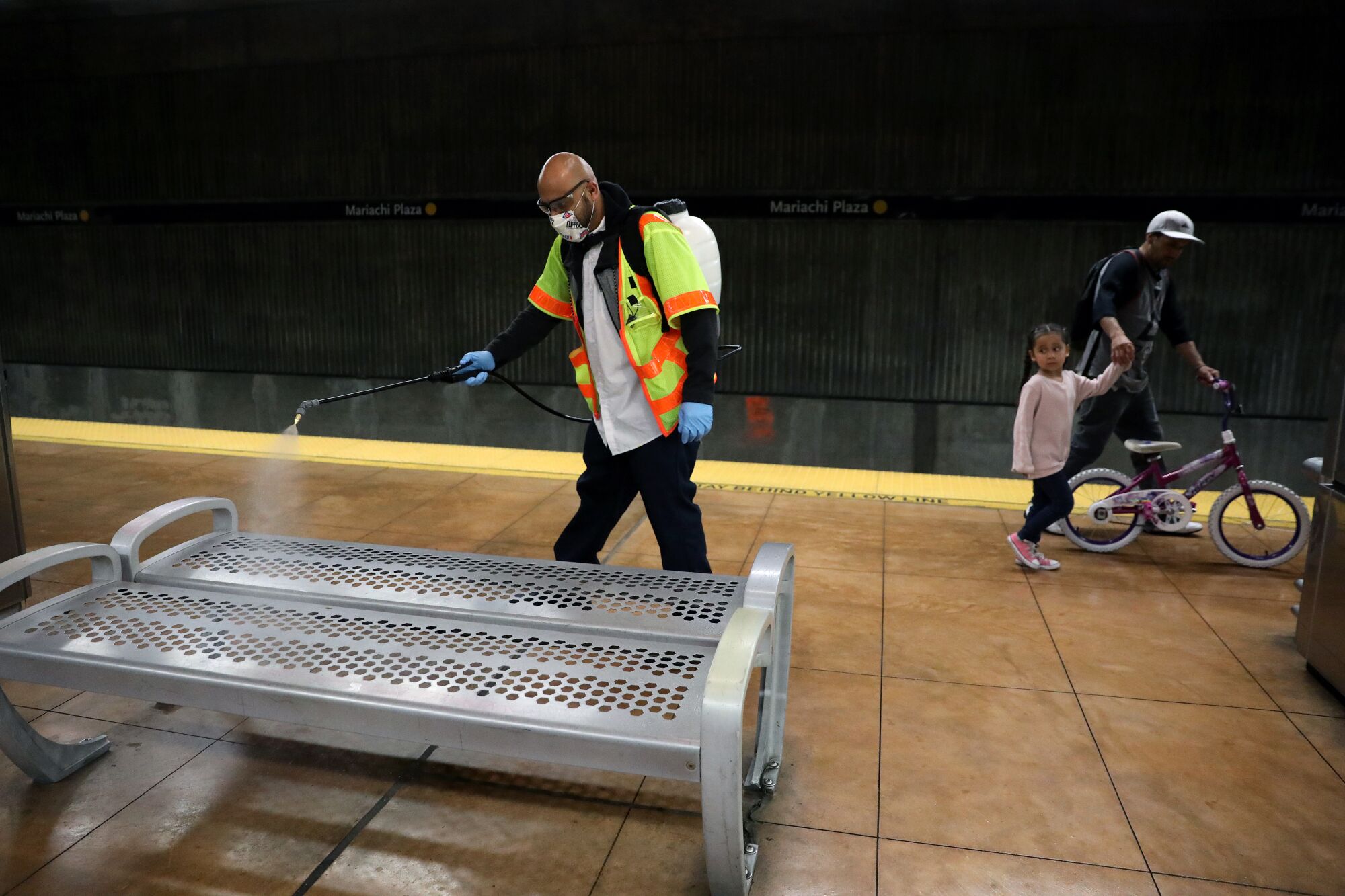 A Metro general service employee disinfects Mariachi Plaza station in Boyle Heights.