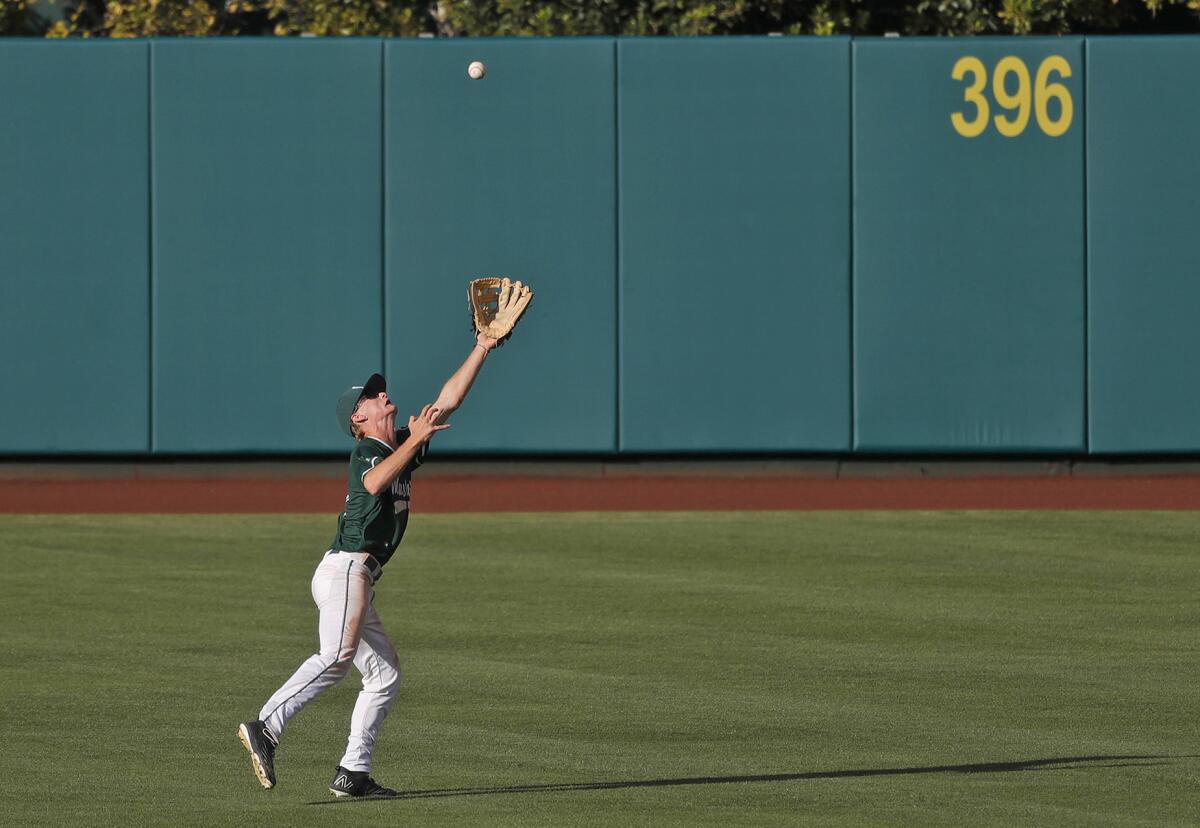 Costa Mesa's Chris Hall makes an acrobatic catch in the outfield during Monday's game.