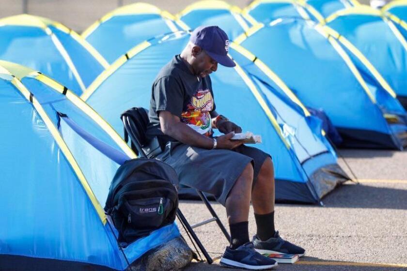 Kevin Tate, 62, shown reading a bible, was one of the first people to take up a tent at the city-sanctioned homeless camp near Balboa Park Golf Course on Oct. 12 2017. (Photo by K.C. Alfred/The San Diego Union-Tribune)
