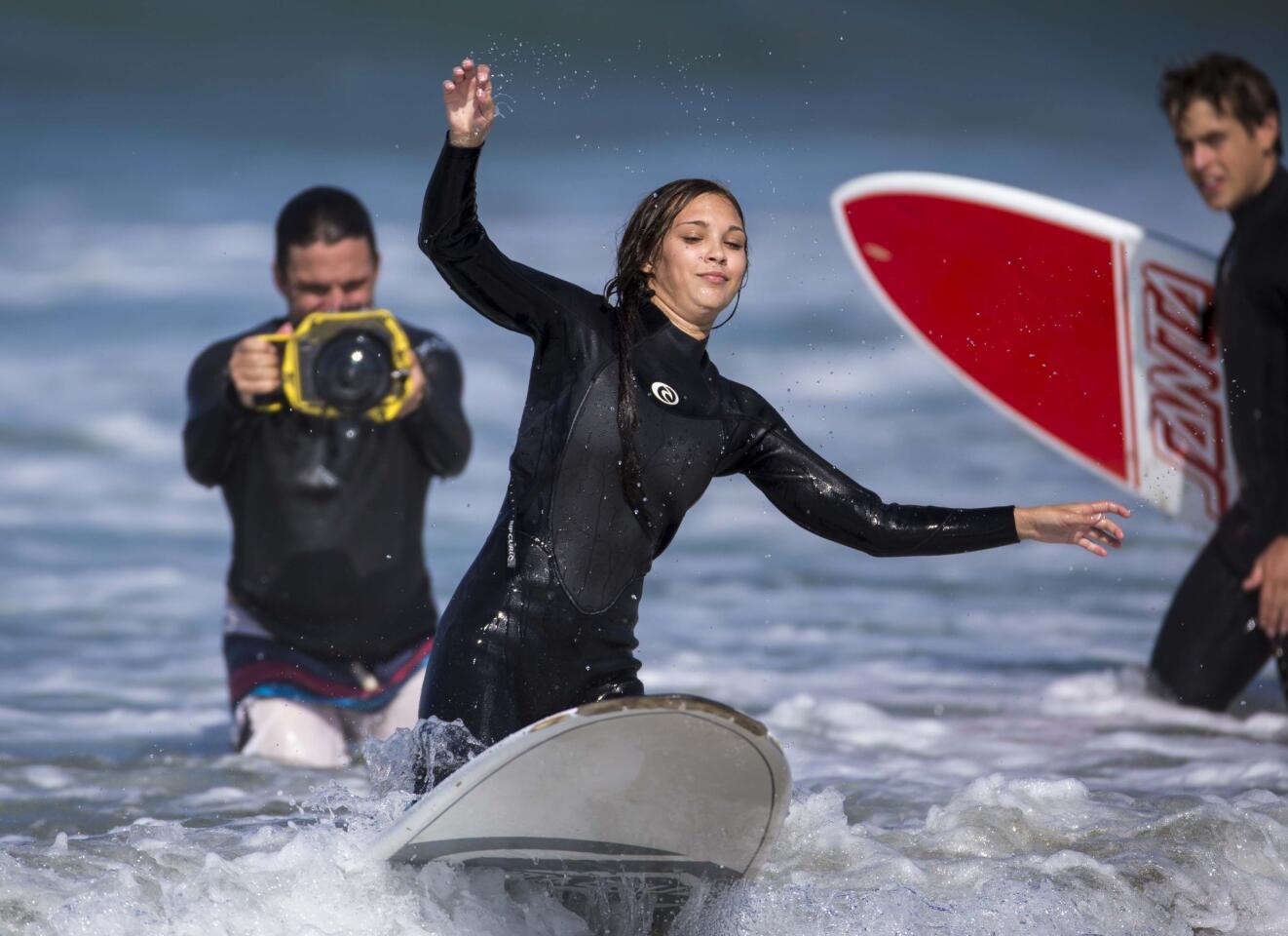 Baylynne tries to stand up while learning to surf as fellow cast member Dash Dobrofsky, right, watches.