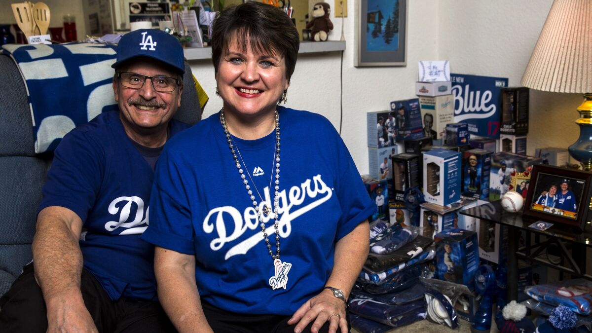 Dodgers fans Bill Snoberger and Mary Jones pose next to their Dodgers memorabilia.