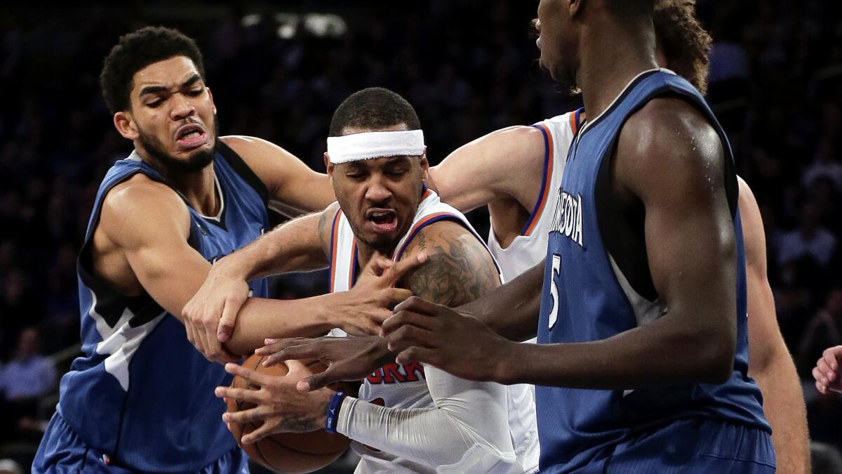 Knicks forward Carmelo Anthony tries to fight through the double-team defense of Timberwolves big men Karl-Anthony Towns, left, and Gorgui Dieng (5) Wednesday night.