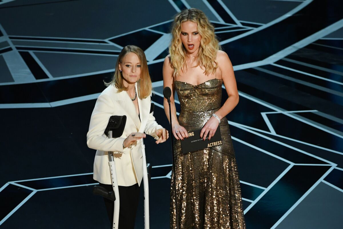 Jodie Foster, left, and Jennifer Lawrence speak onstage during the 90th Academy Awards.