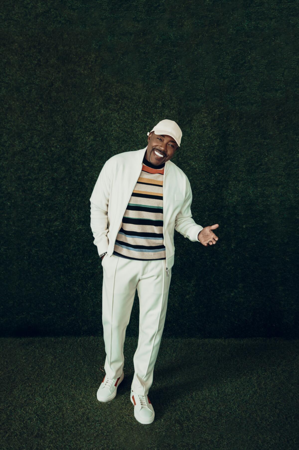 Producer Will Packer in white pants and white jacket over a striped shirt