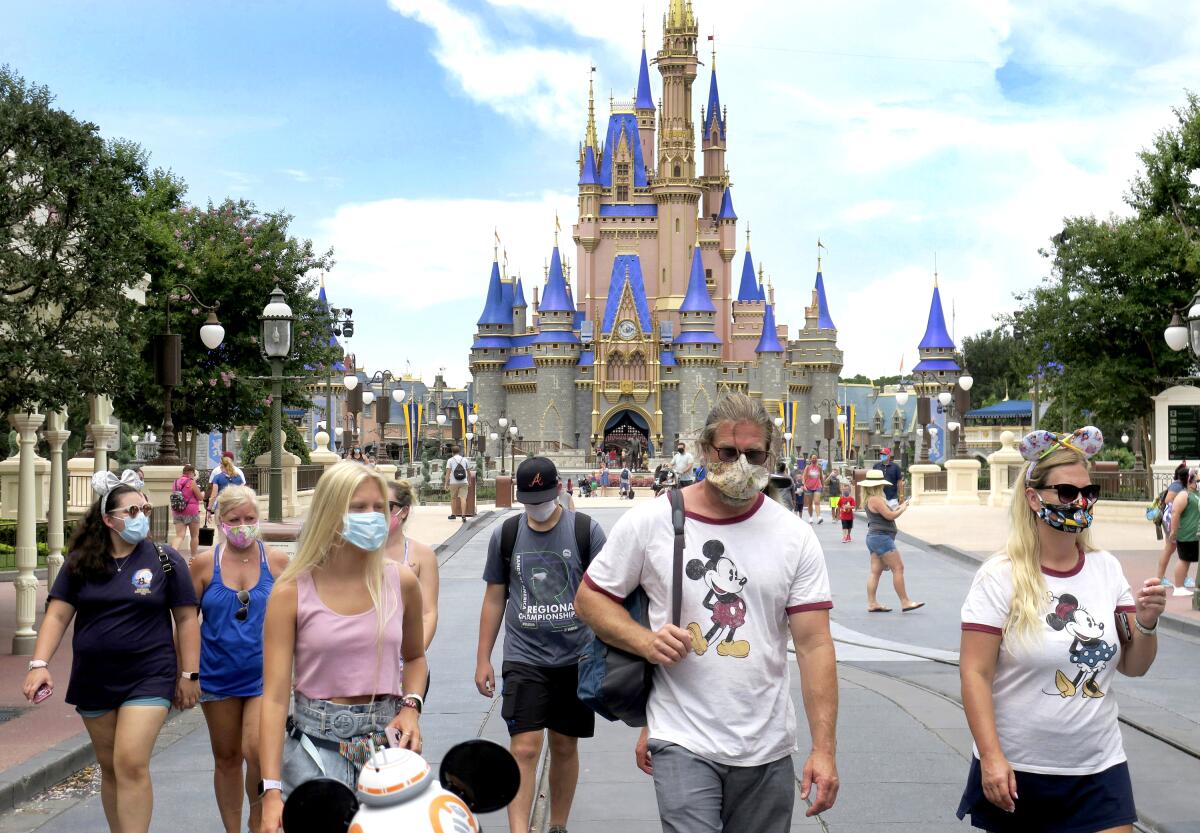 Guests wear masks at the Magic Kingdom at Disney World.
