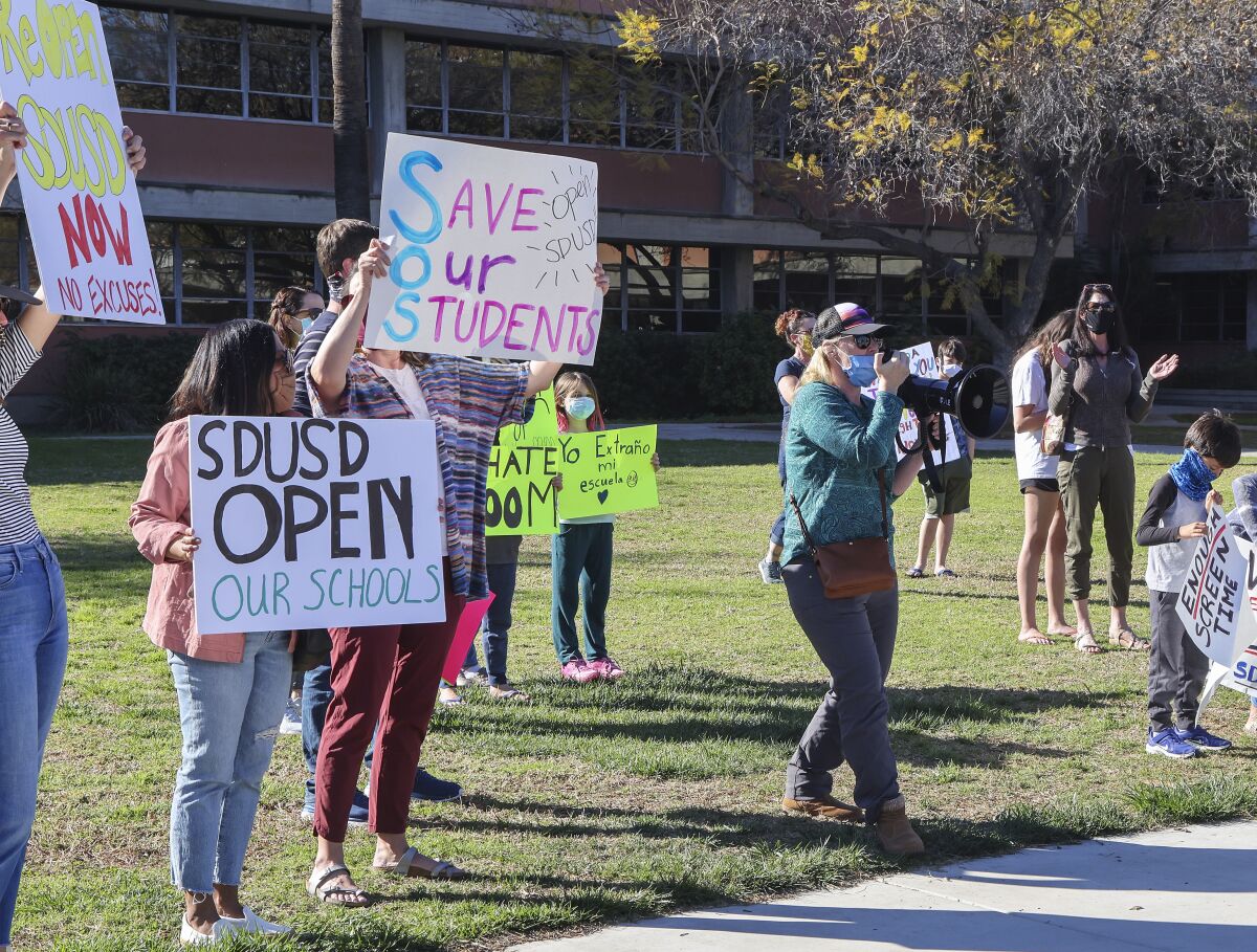 Parents and students rally to reopen schools outside the SDUSD Board of Education Headquarters on Tuesday.
