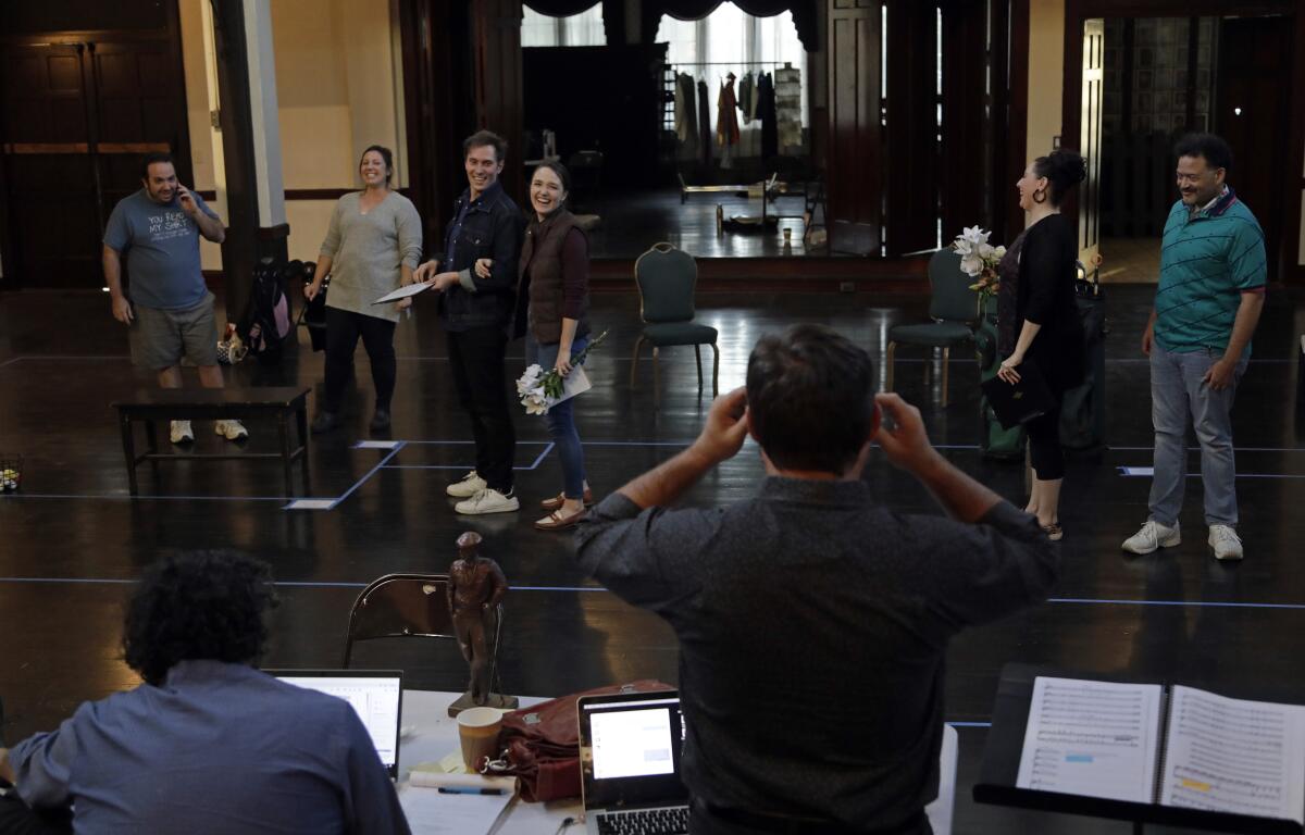 Cast and crew of Pacific Opera Project's "Covid fan Tutte" share a laugh while rehearsing.