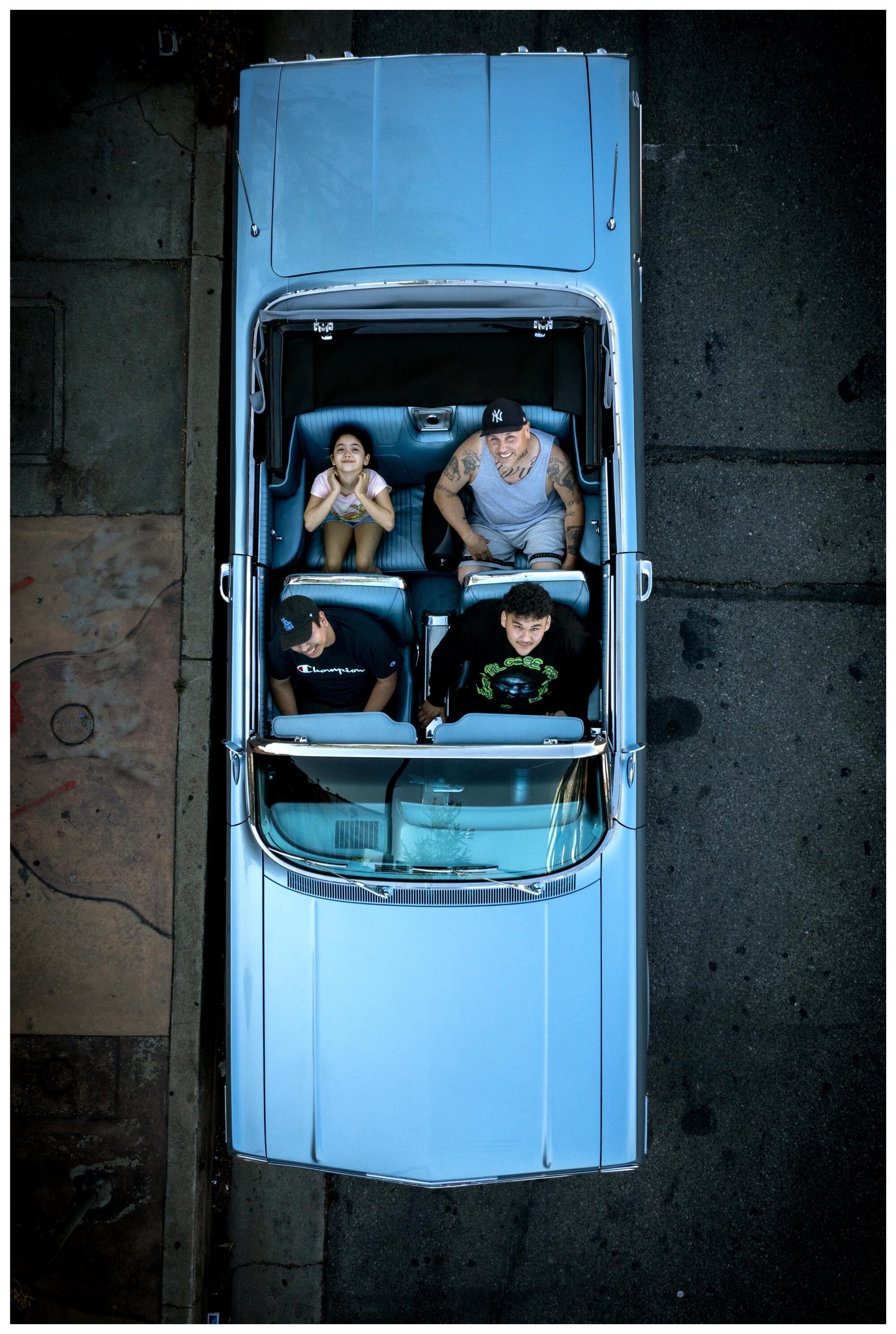 Mario Garcia II, Alexis Alejandre, Mario Garcia and Karla Ramirez show off their 1963 Chevrolet Impala Super Sport.