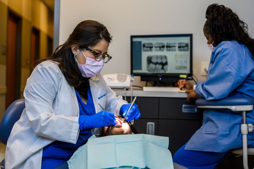 West Memphis, Ark. - Dentist Michelle Freire-Troxel, from left, cleans the teeth of Amari Harris, while Dental Assistant, Chyna Miller, takes notes at the East Arkansas Family Health Center in West Memphis, Ark. on Friday March 6, 2019. CREDIT: William DeShazer