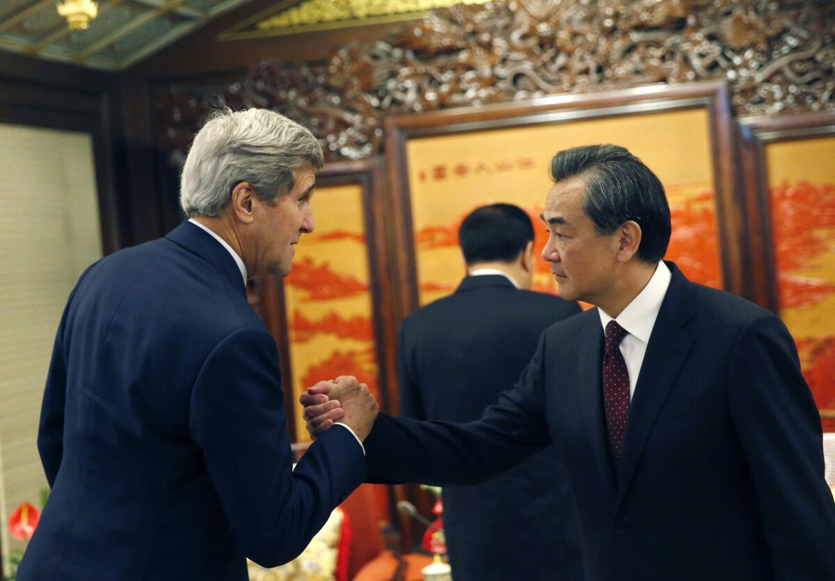U.S. Secretary of State John Kerry, left, shakes hands with Chinese Foreign Minister Wang Yi as he meets Chinese Premier Li Keqiang, center, at the Zhongnanhai Leadership Compound in Beijing on Saturday.