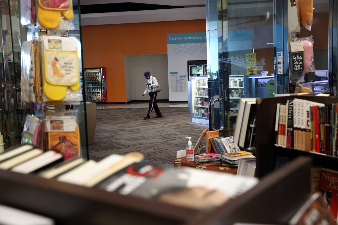 A person walks past Malik Books at the Baldwin Hills Crenshaw Plaza.