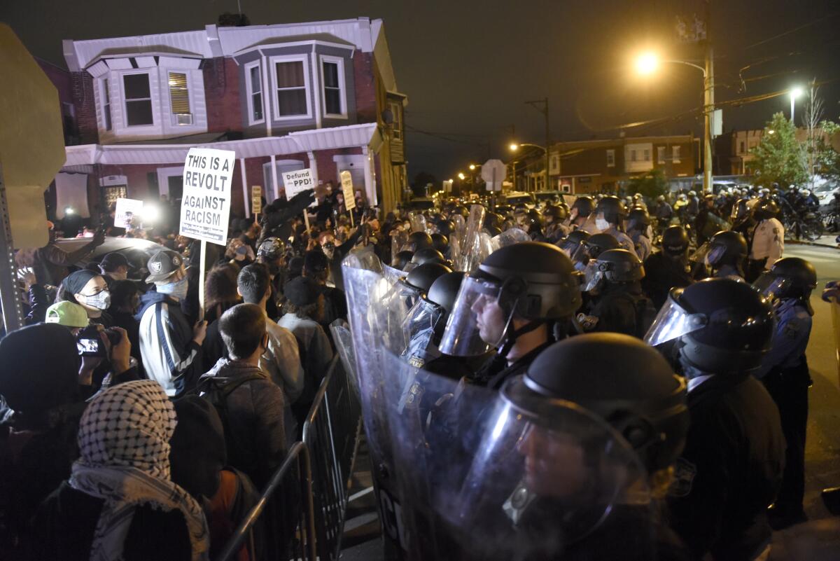 La policía vigila a manifestantes en Filadelfia luego de que la muerte de un individuo de raza negra a manos de la policía.