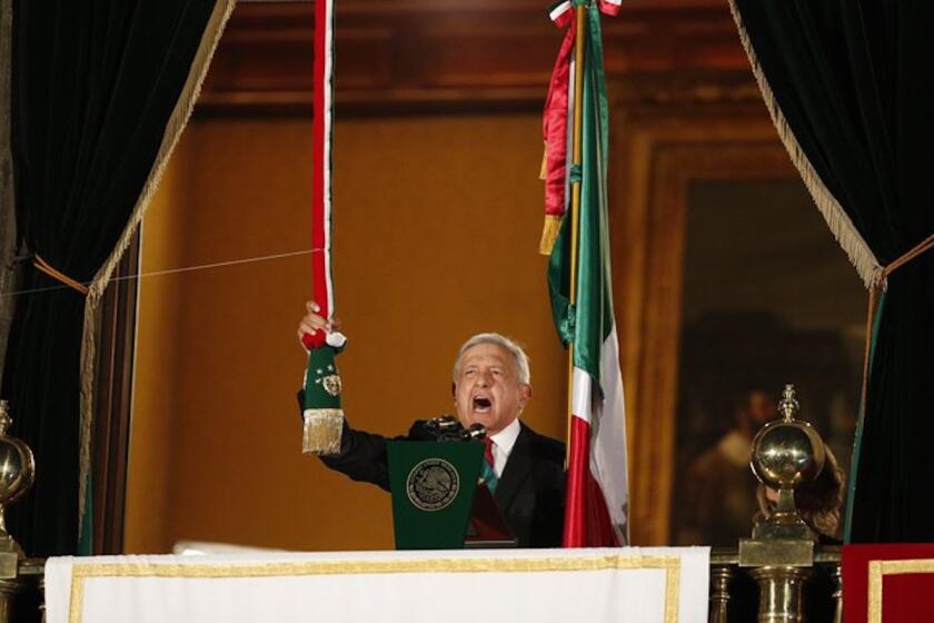 El presidente de México, Andrés Manuel López Obrador, hace sonar una campana mientras da el "grito" tradicional con motivo del Día de la Independencia en el balcón del Palacio Nacional, en Ciudad de México.