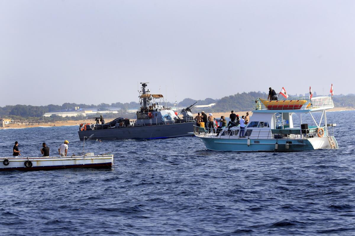 Lebanese protesters sail near an Israeli navy vessel