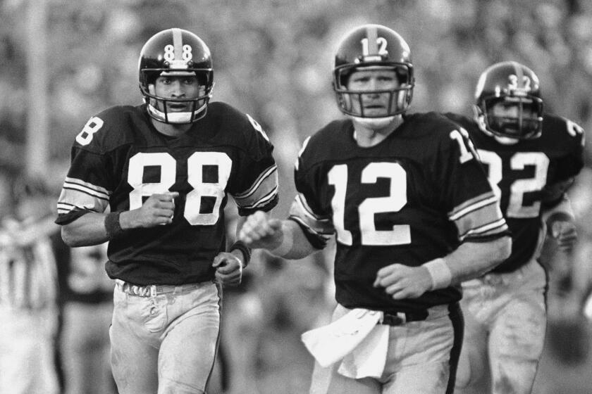 Pittsburgh Steelers receiver Lynn Swann (88) and quarterback Terry Bradshaw (12) watch action against Los Angeles Rams during Super Bowl XIV game in Pasadena, California on Sunday, Jan. 21, 1980. Bradshaw threw a touchdown pass to Swann which helped spark Steelers 31-19 win over the Los Angeles team. (AP Photo/Suzanne Vlamis)