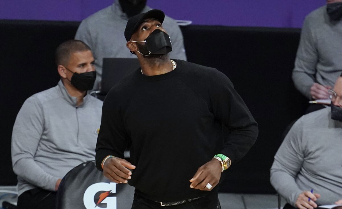 Lakers forward LeBron James looks up at the scoreboard from the sideline.