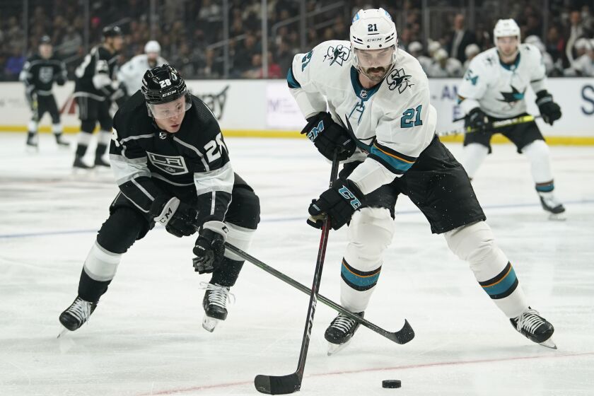 San Jose Sharks defenseman Jacob Middleton (21) controls the puck against Los Angeles Kings center Jaret Anderson-Dolan (28) during the second period of an NHL hockey game Thursday, March 10, 2022, in Los Angeles. (AP Photo/Ashley Landis)