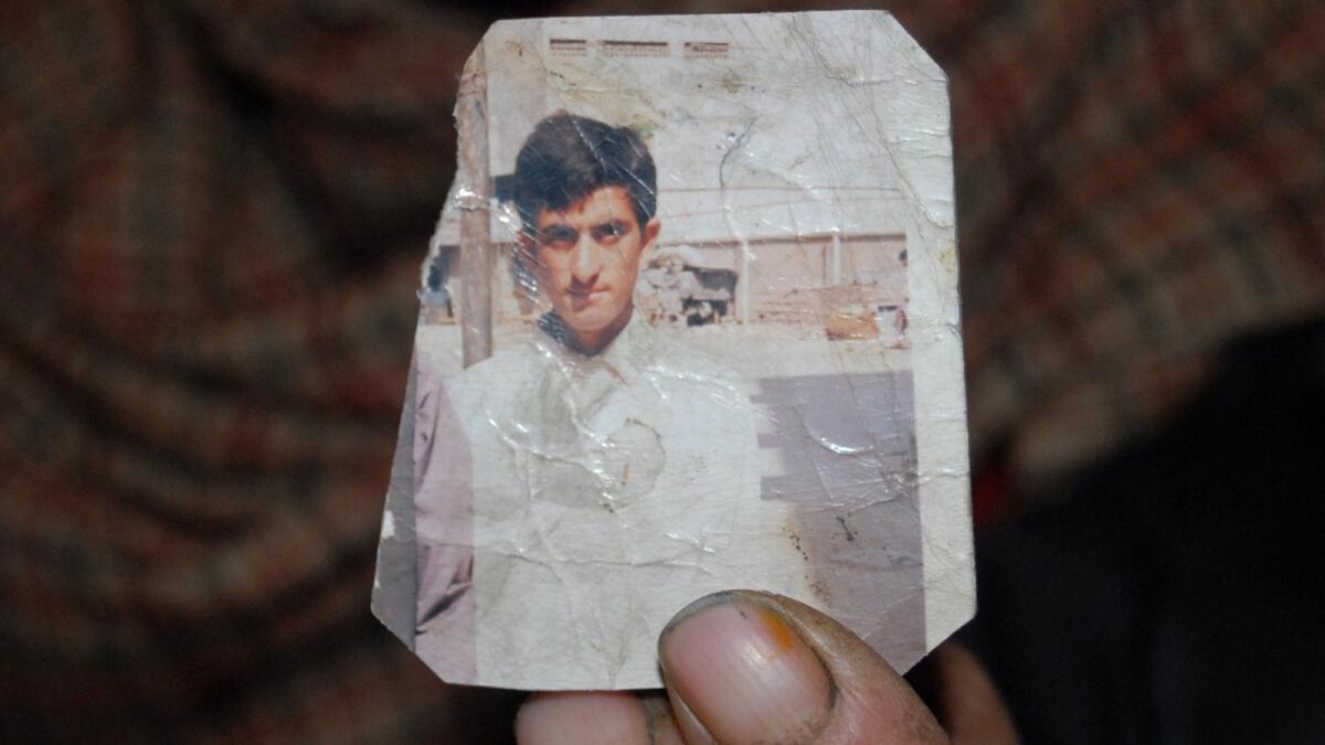 One of Shafqat Hussain's parents holds a photograph of him.