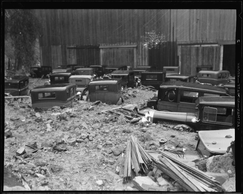 1930s-era cars are buried in mud.